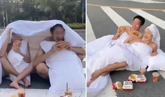 男女裹床单躺斑马线拍婚纱照 另有一名女子专挡道