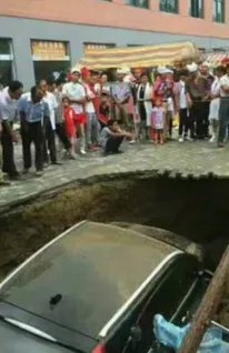 路面塌陷小车坠坑后却围满戴孝人?