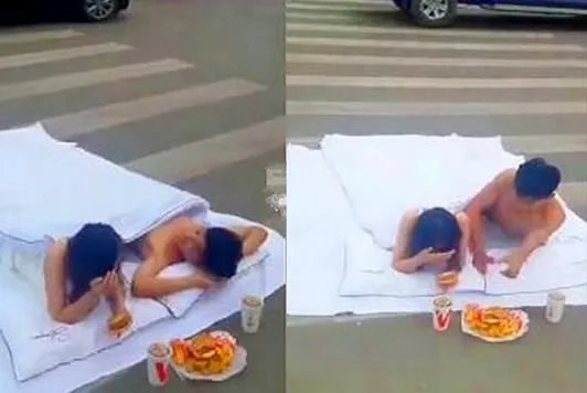 男女裹床单躺斑马线拍婚纱照 另有一名女子专挡道