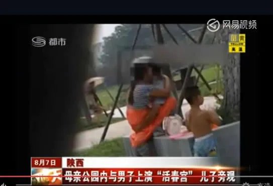 母亲与男子在公园上演：儿子一旁玩耍（图）